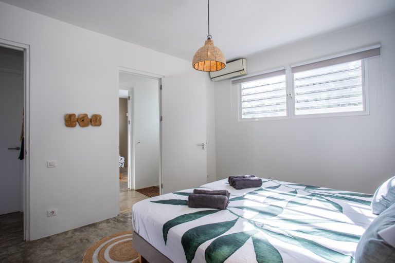 Slaapkamer met tropische details in vakantievilla Curaçao